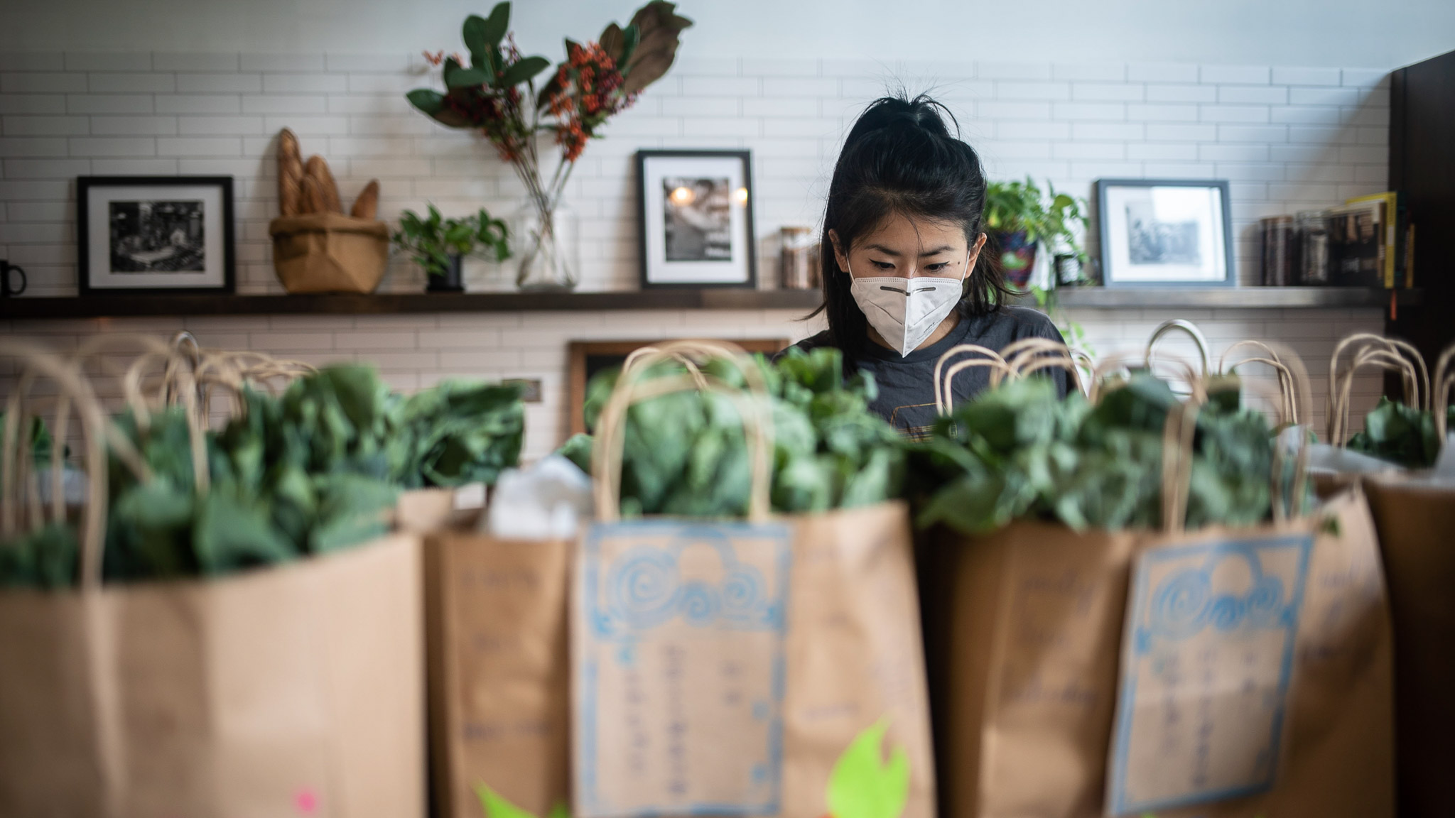 Chinatown volunteer Yin Chang checks on bags of food her and other volunteers have put together for Asian elderly folks.