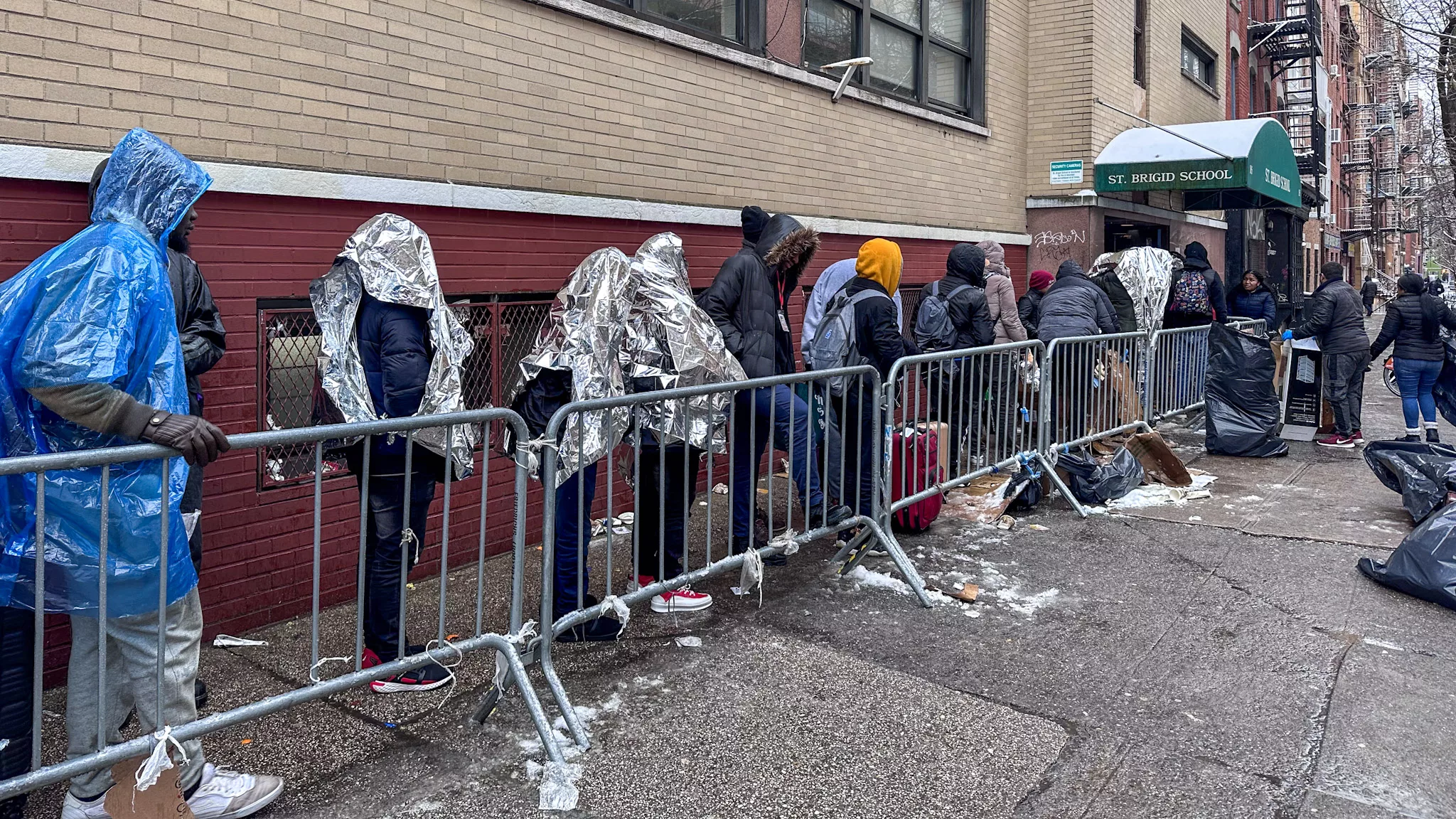 数百名移民在零下温度中等待外面的避难所中的调动 - 详细记录