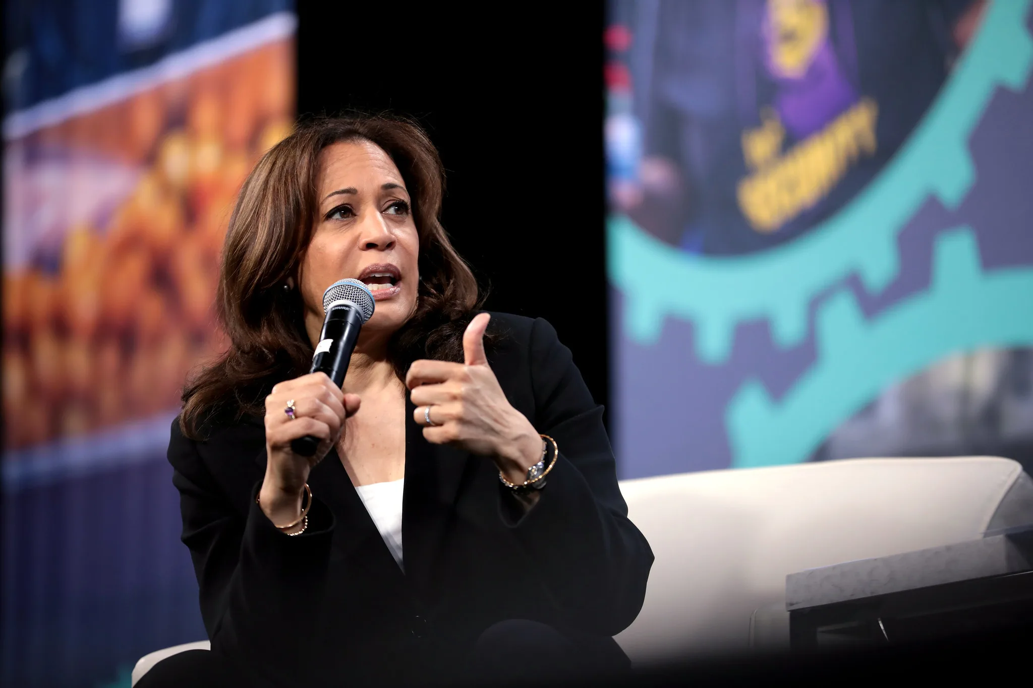 Vice President Kamala Harris speaks into a microphone at an event.