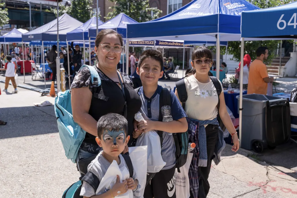 Doris Aguiler with her son and nephews at the back-to-school fair in Jackson Heights. Photo by Rommel H. Ojeda for Documented