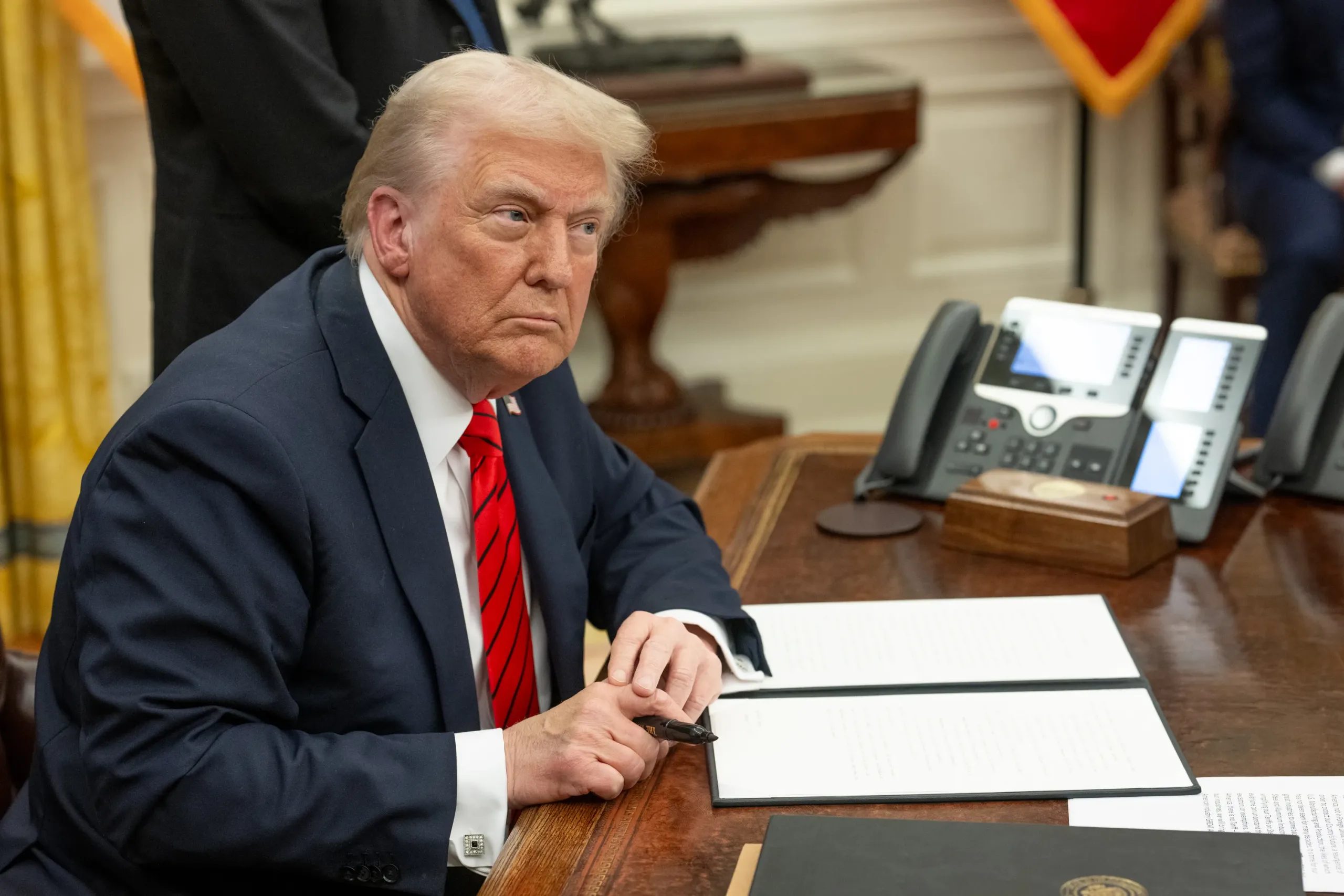 Trump sits at his desk in the Oval Office.